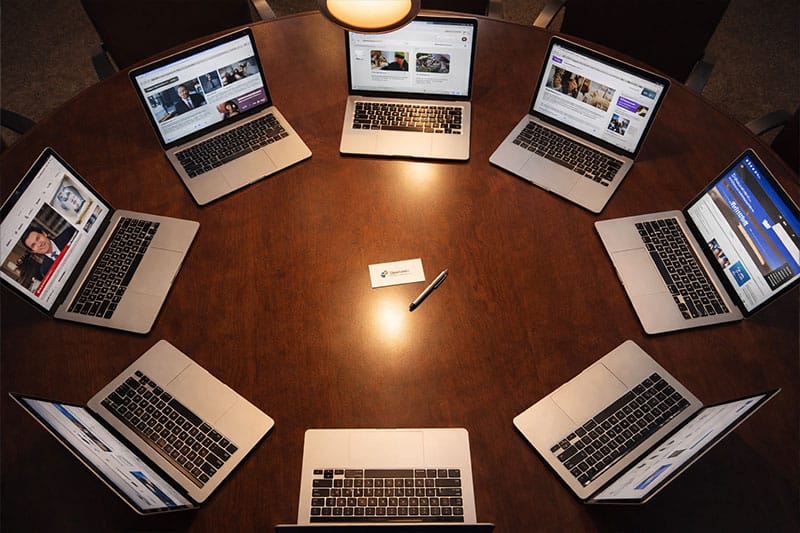 Business card placed among multiple authoritative website screens representing parasite SEO strategy